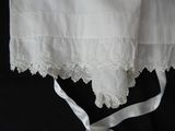a close up of a white dress with a white ribbon