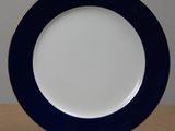 blue and white plate with a gold rim on a wooden table