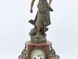 une statue représentant une femme debout au sommet d'une horloge