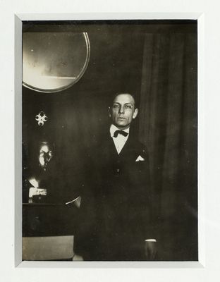 photographie en noir et blanc d'un homme en smoking posant pour une photo