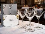quatre verres à vin posés sur une table sur laquelle se trouve une boîte