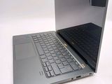 a silver laptop with a black keyboard on a white surface