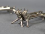 silver plated cat cufflinks on a gray surface
