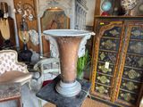 a large vase sitting on a pedestal in a room