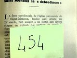 un bout de papier posé sur un livre, sur lequel est collé un autocollant