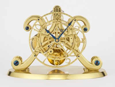 une horloge dorée avec des aiguilles bleues sur fond blanc