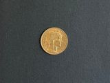 a close up of a gold coin on a black surface