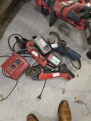 une personne debout à côté d'un tas d'outils posé par terre