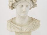 un buste en marbre blanc représentant une femme avec des fleurs sur la tête