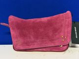 Le sac à main en daim rose se trouve à côté d'un passeport et d'un étui à passeport