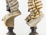 pair of antique busts of women with hats and scarves on them