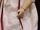 a doll that is wearing a white dress and red shoes