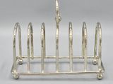 a silver plated toaster that has five slices of bread in it