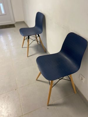 two blue chairs sitting next to each other in a room