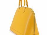 the yellow handbag is sitting on a white surface