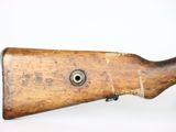an old wooden rifle with a metal bolt on the side of it