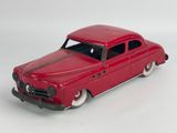 a red toy car that is sitting on a white surface