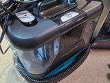 a vacuum that is sitting on the floor next to a laptop