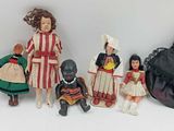 a lot of dolls that are sitting on a white surface