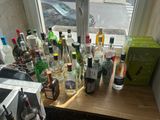 de nombreuses bouteilles d'alcool posées sur un comptoir près d'une fenêtre