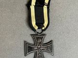 an iron cross with a black ribbon on a gray surface