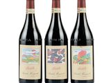 trois bouteilles de vin rouge posées l'une à côté de l'autre sur une surface blanche