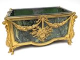 a green and gold box with a gold decoration on it