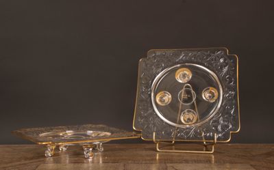 un plateau en argent orné d'une horloge, posé sur une table en bois