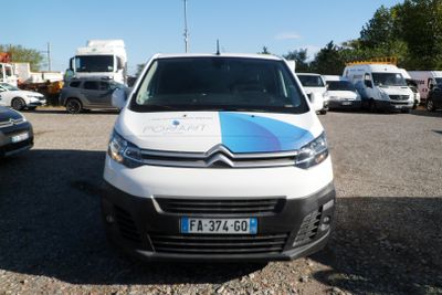 a white van with a blue and white stripe parked in a parking lot