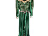 a green dress hanging on a hanger on a white wall