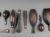 several wooden spoons and spoon knives are lined up on a gray surface
