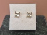 a pair of earrings sitting on top of a white cloth