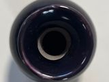 a black vase that is sitting on a white table