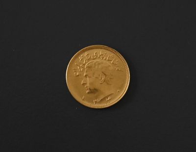 a close up of a gold coin on a black surface