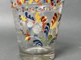 a glass cup with a colorful floral design on it