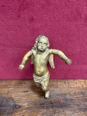 an antique brass figurine of a baby with a diaper