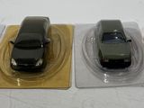 two toy cars sitting on top of each other on a table