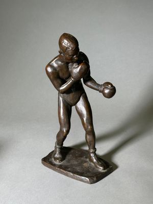 statue d'un homme tenant une batte de baseball et une balle sur une base