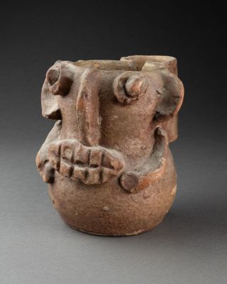 an image of a clay vase with a face on it