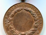 une vieille médaille en bronze ornée d'une couronne, posée sur un fond blanc