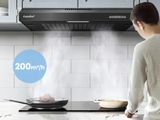 un homme debout dans une cuisine, avec une poêle posée sur la cuisinière