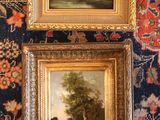 deux tableaux encadrés représentant un paysage et un arbre, posés sur un tapis