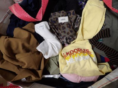 a suitcase full of clothes and a bag with a hoodie on it