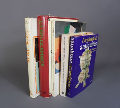 plusieurs livres sont empilés sur une surface grise