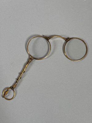 a pair of gold colored scissors on a white surface