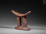 a small wooden stool with a curved seat on top of it