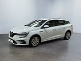 Une voiture blanche est garée dans une pièce blanche au sol noir.
