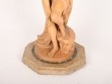 statue of a woman holding a bird on a pedestal