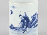 une image représentant une tasse bleue et blanche sur laquelle figure un homme dans un bateau sur l'eau