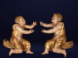 two statues of a man and a woman are sitting on a blue surface